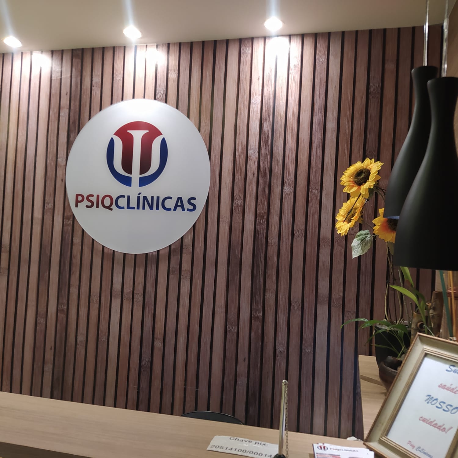 Logo da Clínica PSIQ na parede da recepção